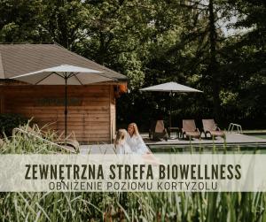 a woman is sitting next to a swimming pool at Hotel Dębowy Biowellness & SPA Góry Sowie in Bielawa