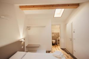 an attic bedroom with a bed and a skylight at Albola Suite Holiday Apartments in Riva del Garda +285 photos