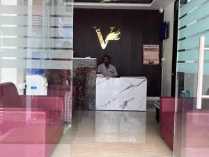 a man sitting at a counter in a restaurant at Hotel V Stay in Chennai