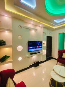 a living room with a flat screen tv on a wall at Gustavó Premium Apartment in Benin City