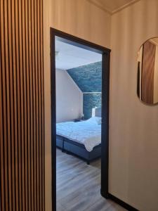 a room with a bedroom with a bed and a mirror at Nes-Tijd in Nes