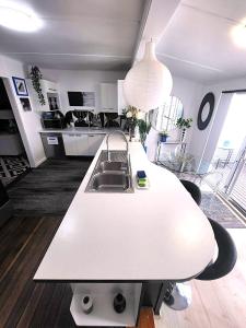 a kitchen with a white counter top and a sink at Eleda House Hunter Valley Escape in Cessnock