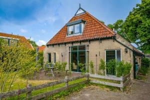 a small brick house with an orange roof at Nes-Tijd in Nes