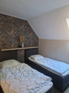 a bedroom with two beds in a room at Nes-Tijd in Nes +5 photos