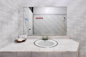 a white bathroom with a sink and a mirror at OYO 3934 Hotel Istana in Pekalongan