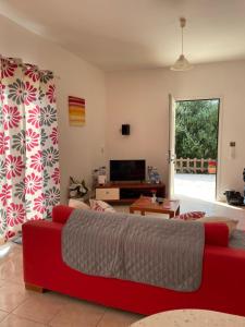 ein Wohnzimmer mit einem roten Sofa und einem Fernseher in der Unterkunft Villa Midas in Zóla