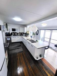a large kitchen with white cabinets and a sink at Eleda House Hunter Valley Escape in Cessnock +36 photos
