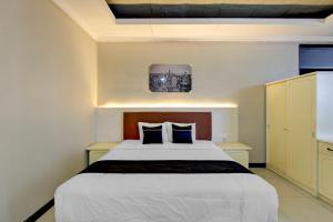 a bedroom with a large white bed with blue pillows at OYO 3934 Hotel Istana in Pekalongan