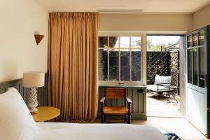 a bedroom with a bed and a sliding glass door to a patio at La Maison du Bassin in Cap-Ferret