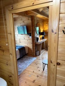 a room with a bed in a wooden cabin at Trelew Farm Log Cabin in Penzance