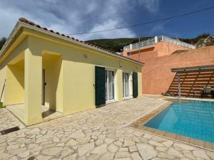 ein Haus mit Swimmingpool neben einem Gebäude in der Unterkunft Villa Midas in Zóla