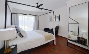 a bedroom with a canopy bed and a mirror at Hacienda in Cape Town +15 photos