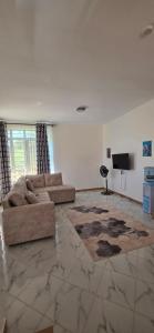 a living room with a couch and a television at Mihambos one bedroom in Msambweni