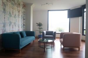a living room with a couch and two chairs and a table at Apartamentos Salceda in Noja