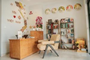 a room with a chair and a shelf of books at The Happy Marina Hotel Phú Quốc - Sunset & Ocean View in Phú Quốc