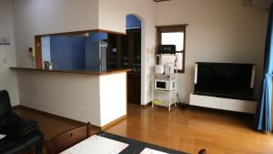 a living room with a television and a living room with a couch at Sakuraya 亀島店 in Nagoya