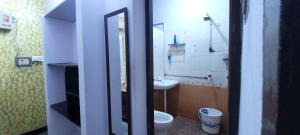 a bathroom with a sink and a toilet and a mirror at Uthamar Illam in Tiruchirappalli