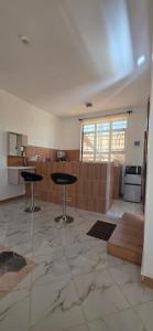 a kitchen with two tables in the middle of a room at Mihambos Apartments in Msambweni