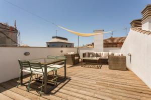 a patio with a table and chairs on a roof at Realejo Horizon por Miwa Studio in Granada