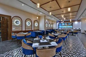 a restaurant with tables and chairs in a room at The Grand Anukampa in Jaipur