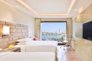 a hotel room with two beds and a large window at Courtyard by Marriott Bengaluru Hebbal in Bangalore