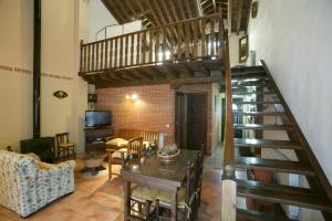 a living room with a staircase and a table and chairs at La Rinconera in Mingorría