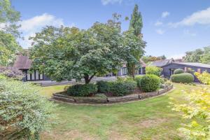 an exterior view of a house with a tree in the yard at Frith Farm House Cottages in Newnham
