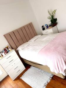 a bedroom with a bed and two white night stands at Sonique-Uniqueness Crib in Cape Town +3 photos