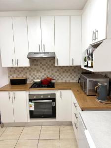 a kitchen with white cabinets and a stove top oven at Sonique-Uniqueness Crib in Cape Town