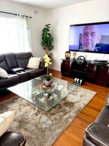a living room with a glass coffee table and a tv at Sonique-Uniqueness Crib in Cape Town