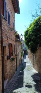 an alley with an old stone building and a street at Il Vicolo in Cagli