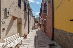 an empty alley with a bench in a city at Casa nel Borgo in Campomarino +31 photos