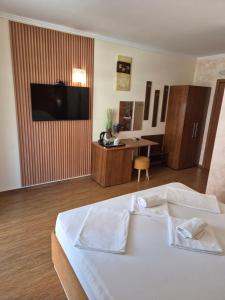 a bedroom with a bed with a television and a desk at Guest Rooms Skalite in Sozopol