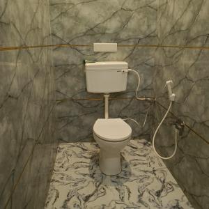 a bathroom with a white toilet in a room at Hotel Kalzug in Katihār +83 photos