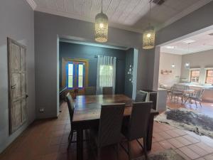 a dining room with a wooden table and chairs at 12 On Milner in Kimberley