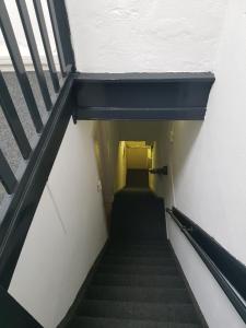 a stairway leading up to a yellow door at Hotel Cafe The Windmill in Schiedam