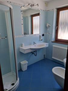 ein blaues Badezimmer mit Waschbecken und Dusche in der Unterkunft Hotel Martinella in Folgaria + 49 Fotos