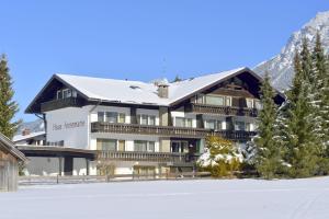 a large building with snow on the ground at Alpenhof Apartments Oberstdorf in Oberstdorf