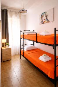 a bedroom with two bunk beds with orange sheets at Sweet Holidays al centro di Formia in Formia