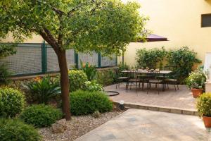 a patio with a table and a tree at Sweet Holidays al centro di Formia in Formia