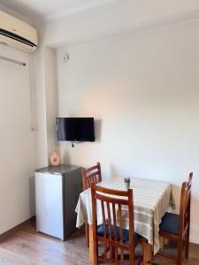 a dining room with a table and chairs and a television at Duka Rooms in Himare