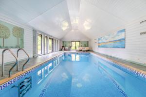 a swimming pool in a house with a large ceiling at Frith Farm House Cottages in Newnham