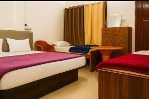 a hotel room with two beds and a table at Grand Ayushmaan - Best Hotel in Jabalpur in Jabalpur