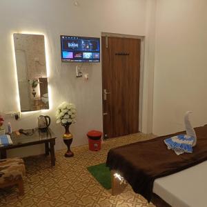 a hotel room with a bed and a television on the wall at Hotel Kalzug in Katihār