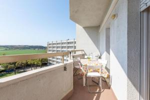 a balcony with a table and chairs and a building at Italian Experience-Suite Riviera in Porto Recanati