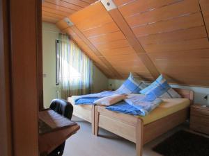 a bedroom with a bed with blue pillows on it at Ferienwohnung Traudel in Hatzenbühl