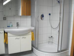 a white bathroom with a shower and a sink at Ferienwohnung Traudel in Hatzenbühl +25 photos