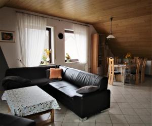 a living room with a black leather couch and a table at Ferienwohnung Traudel in Hatzenbühl