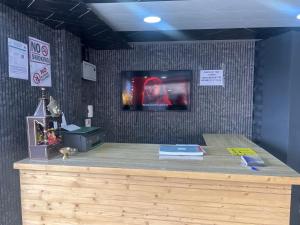 a wooden counter top with a tv on a wall at Glampfire Hotel and Cafe in Jispa
