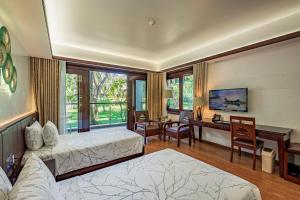 a hotel room with two beds and a desk and a desk at Carmelina Beach Resort Ho Tram in Ho Tram